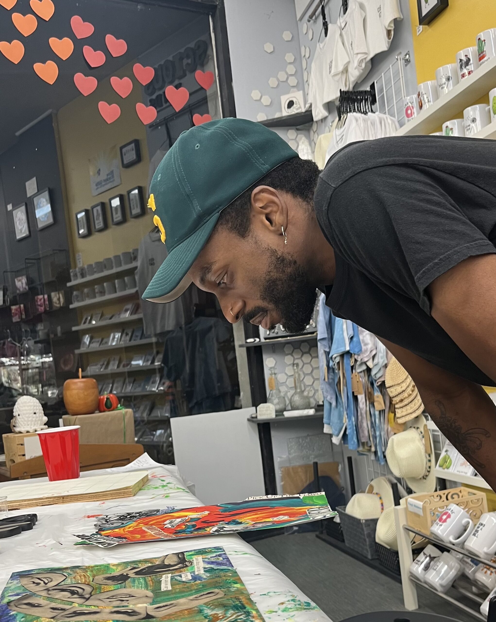 Man examining colorful artwork in a store