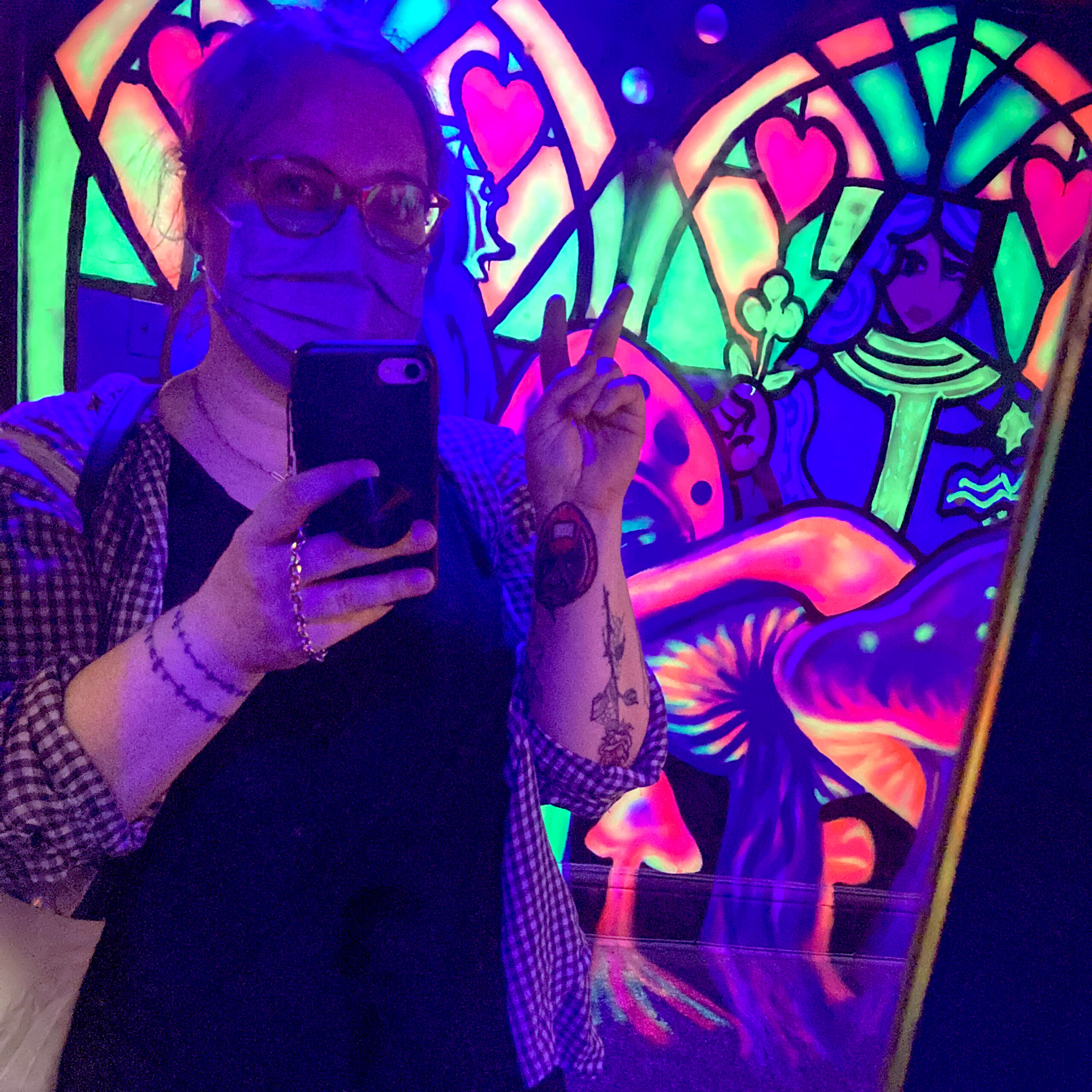 Person taking selfie in neon art room