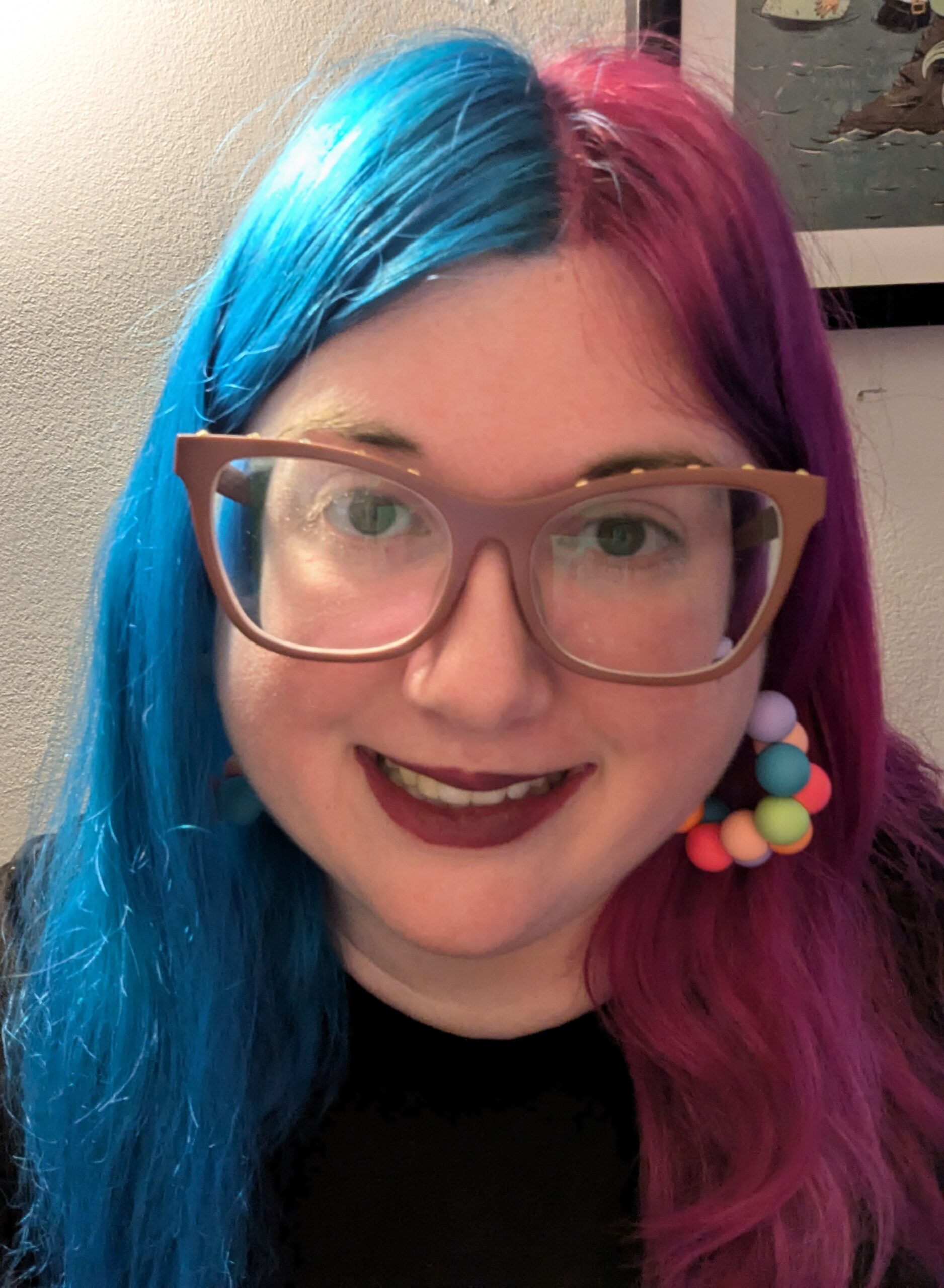 Person with blue and pink hair smiling